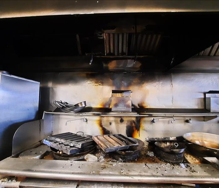 Commercial kitchen with soot, debris, pans, and rollers