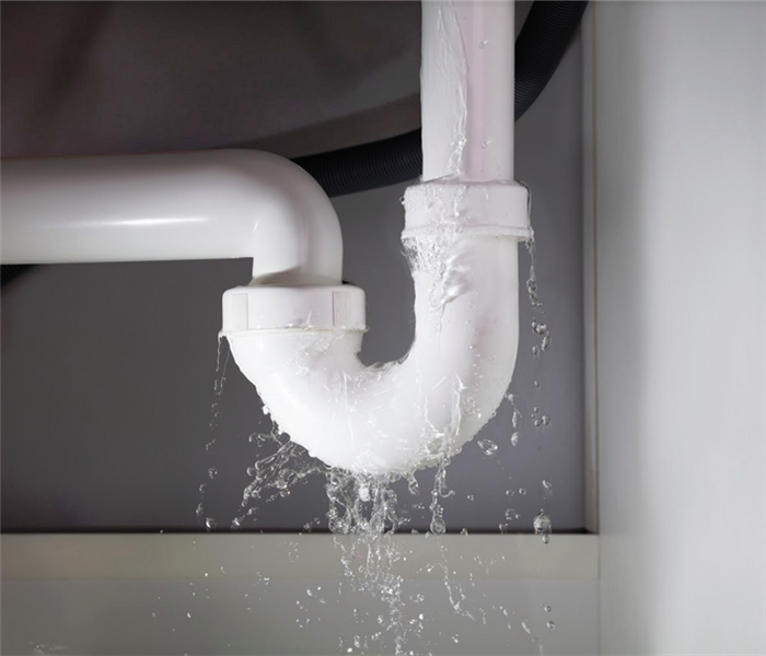 white pipe leaking water under a sink