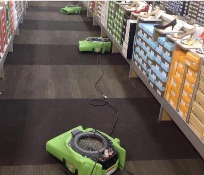 water damaged carpet at shoestore; SERVPRO restoration equipment being used to dry carpet