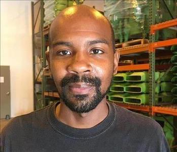 Bald man with facial hair wearing a black shirt and smiling
